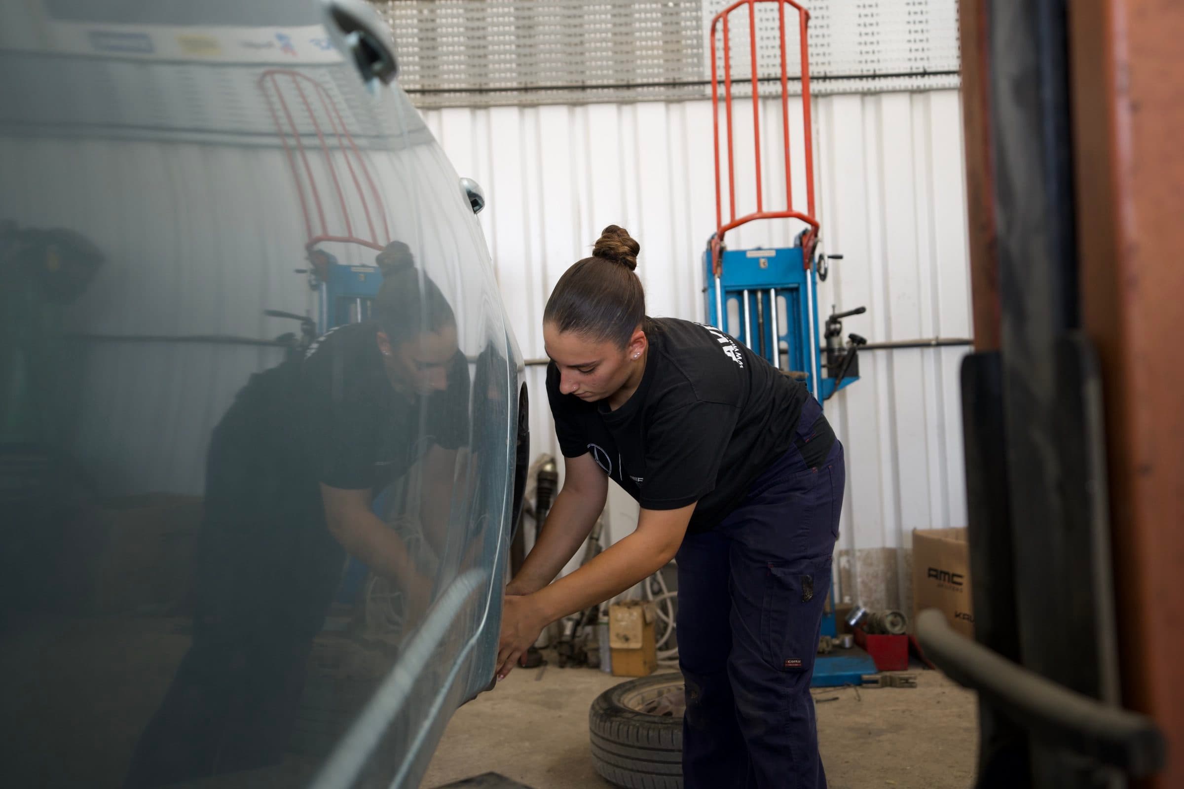 Working on a wheel, reflected in the bodywork