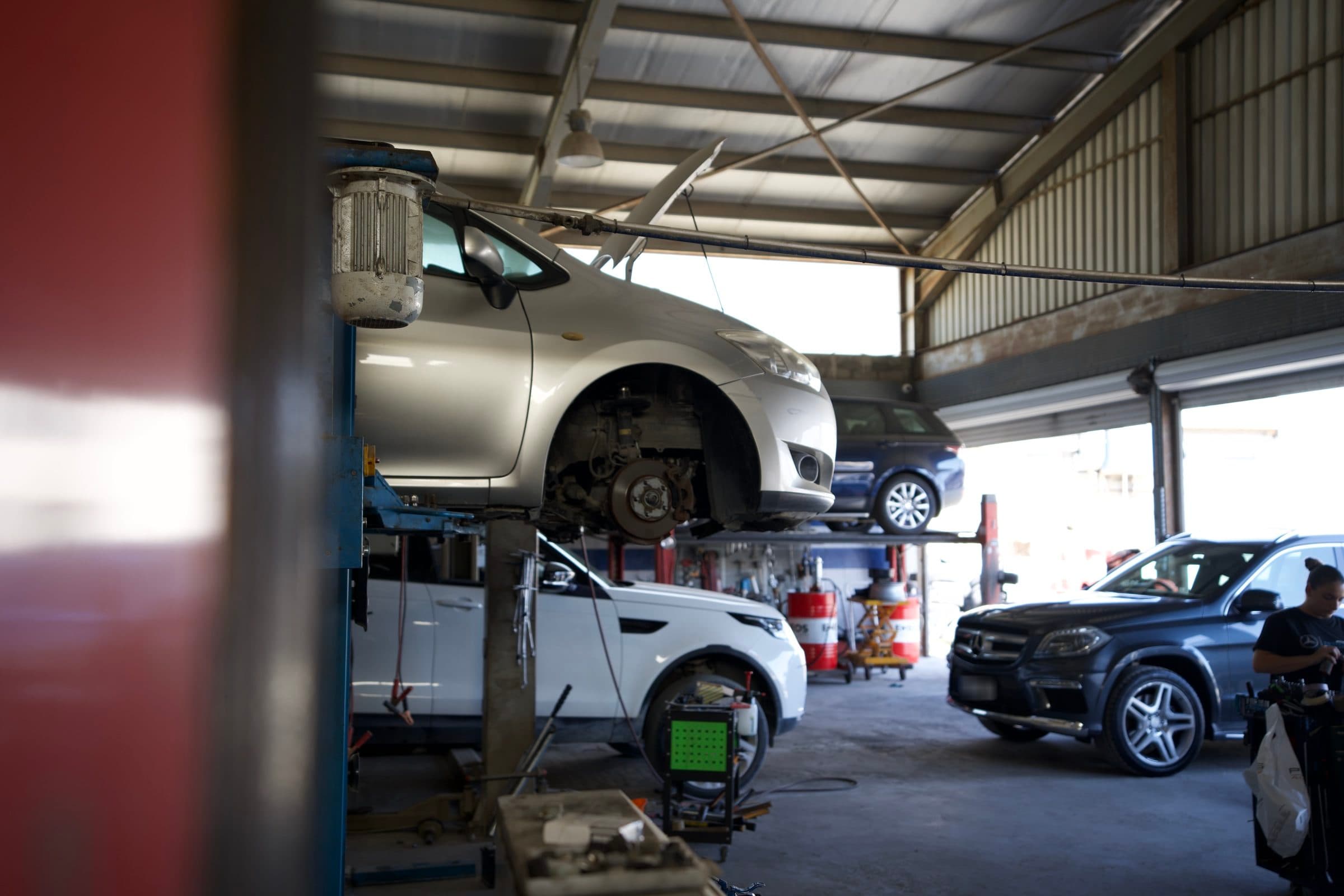 A car raised on a lift with its wheels removed